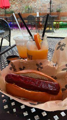 Tang hurricane in take-home glass and burnt ends brisket hotdog.