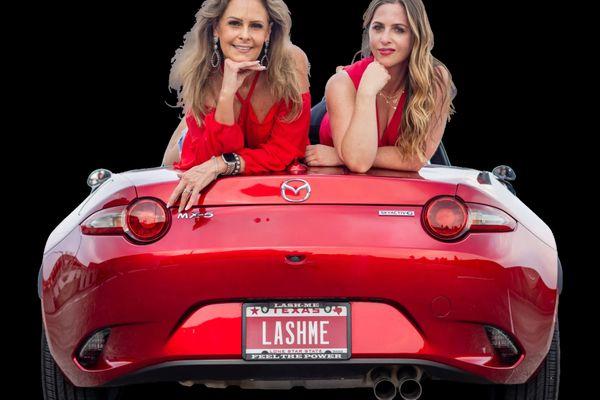 two-girls-laying-trunk-lashme-license-plate.jpg