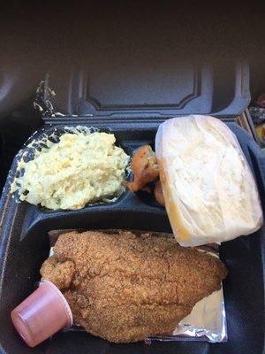 One piece of catfish, as a dinner plate, with hush puppies and potato salad with slice of cornbread.