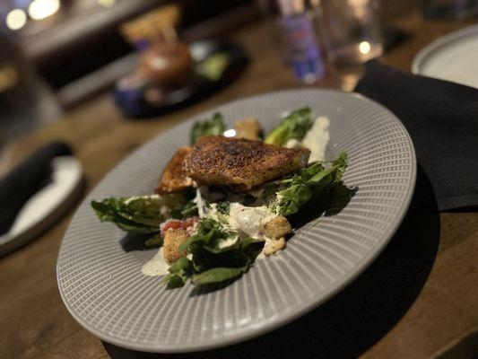 Blackened salmon on Caesar salad.