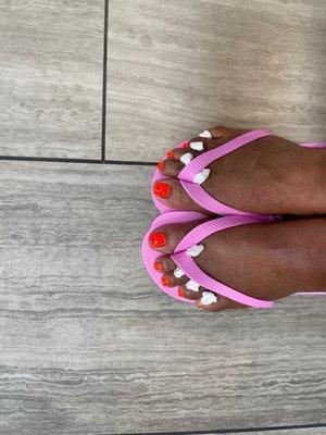 Pedicures feet with Color Club orange polish.