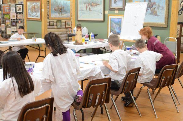 "Discovering Your Art" students painting a lighthouse scene.