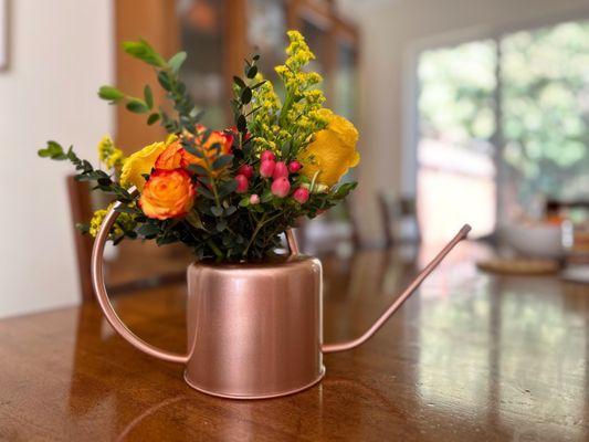 Gorgeous floral arrangement in a decorative water can provided by customer