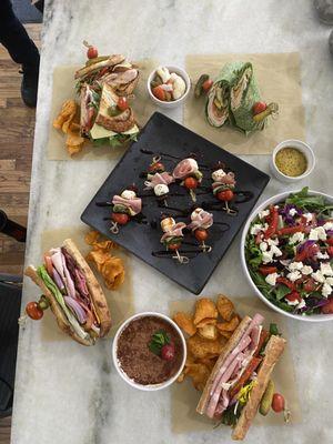 Americano on left, Italiano right in the front, house special on far left, turkey chipotle wrap, Greek salad and antipasto bits.