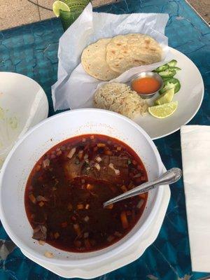 Birria de res soup. (Beef Birria soup.) Comes with rice, limes, and homemade tortillas.