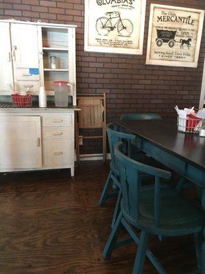 Old chairs and tables and a cupboard in the dining area.