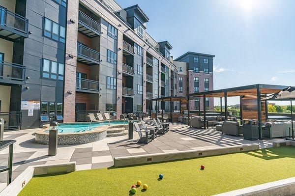 Outdoor patio with dipping pool, bocce court and shaded seating.