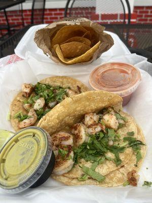 Shrimp tacos with chips and salsa.