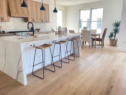 Contemporary kitchen with light wood flooring & kitchen island.