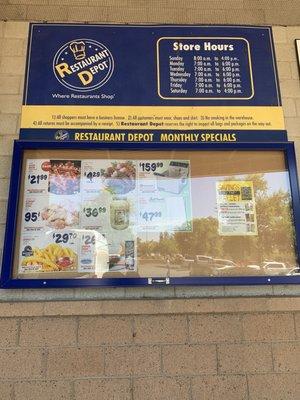 Store hours and monthly specials posted outside the store