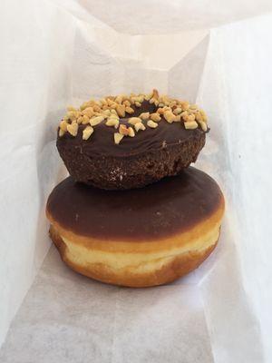 Chocolate cake donut with chocolate glaze and peanuts on top of chocolate glaze donut