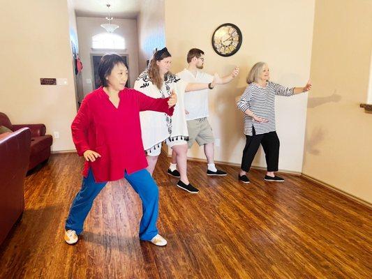 A wonderful mother with her two adult children in a tai chi session.