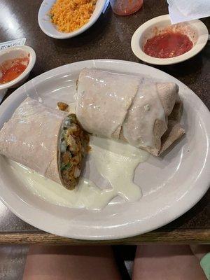 Lunch wrap on a wheat tortilla with chicken, rice, and avocado drizzled with Queso