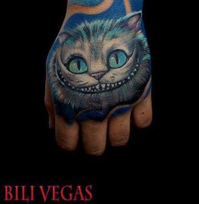 Cheshire cat hand tattoo by traveling pro artist Bili Vegas