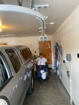 Ceiling lift installed in a garage that allows transfers from a wheelchair and onto the Braun Turny seat of his truck.