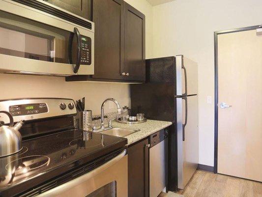 Kitchen equipt with nice stainless steel appliances.