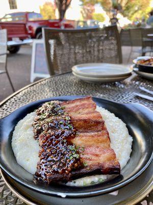 Braised pork belly over grits and sorghum and mustard seed glaze.