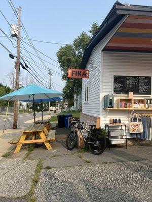 Super cute micro bakery with some seating and a view of some of the merch and menu