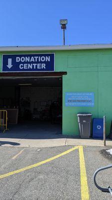 Donation center with hours (clothing bins are to the right)