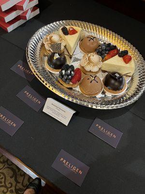 Selection of pastries, including lemon tart, fruit tart, cheesecake, chocolate raspberry domes, and chocolate hazelnut domes.