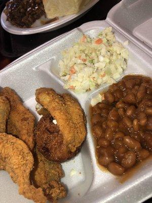 Seasoned fried catfish, hush puppies, coleslaw and baked beans.  Really great tarter too!  Pretty sure they make it in house.