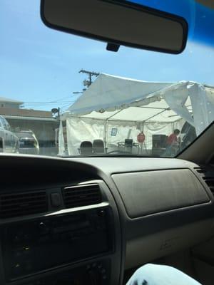 This is your beautiful location and easy access "building". It's literally a white tarp tent held together by PVC pipe in a junkyard.