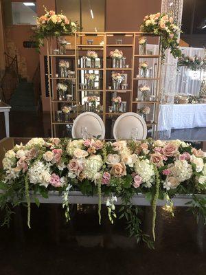 Sweetheart table centerpiece with floral backdrop with flowers and floating candles!