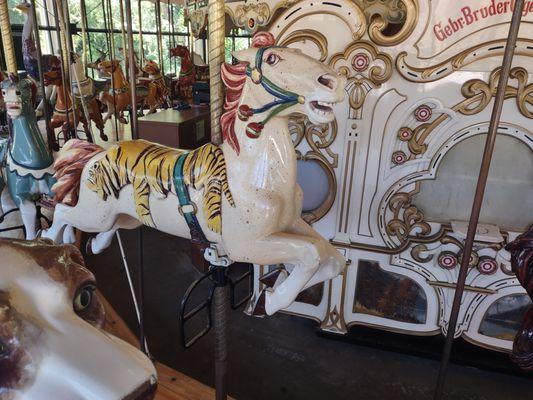 Inside row horse with a tiger pelt for a saddle, and the facade for the antique band organ.