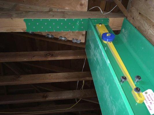 The SkinnyBrace and yellow "fuse" installed, connected to the new 6x8 beam across the garage ceiling with attic shear walls above..