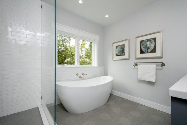 Lovely tile pattern on floor. Bright white tiles on wall.