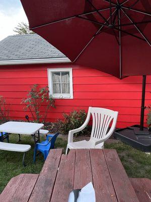 Picnic tables, chairs and sun umbrella - outdoor seating at Too Tall's