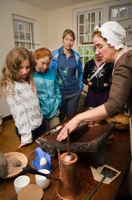 Visitors are invited to share in the chocolate-making experience, adding ingredients to the mix.