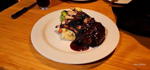 Center Cut Lamb 1/2 Rack grilled with cherry-garlic sauce and served with mashed Yukon Gold potatoes and vegetables.