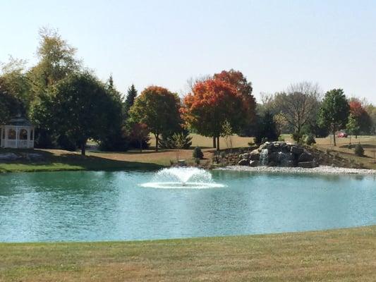 Beautiful pond with walking trail on one side of it.