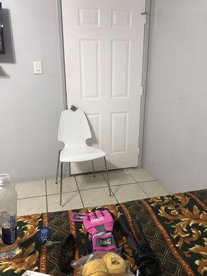 Chair propped under door for security. No latch