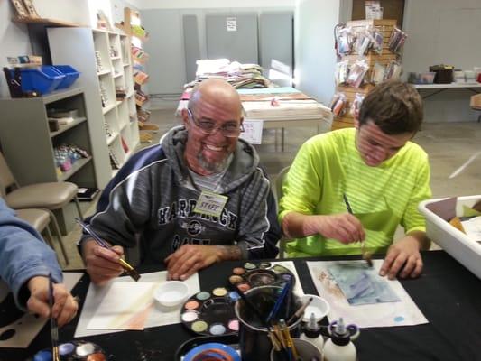 Steampunk Ed and his son creating an owl with at papers during the Grand Opening