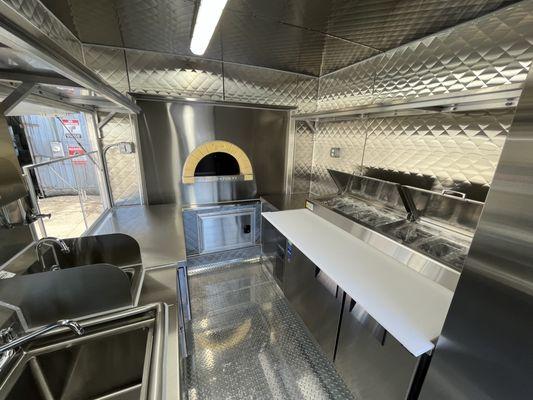 Fiero Forni pizza oven installed on a food trailer with the back half of the pizza oven on the porch area.