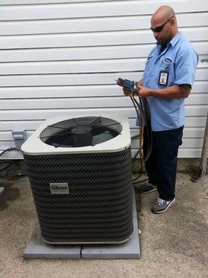 Preston, one of our service technicians, performing a check on an air conditioner.