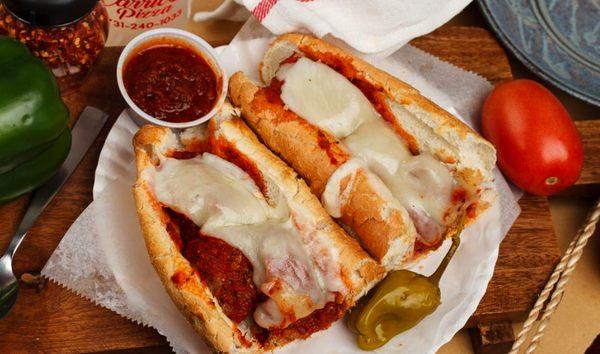 Meatball sub with meatballs, cheese and marinara sauce.