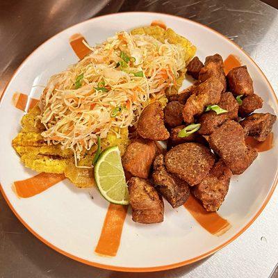 Fried Pork served with spicy slaw and tostones