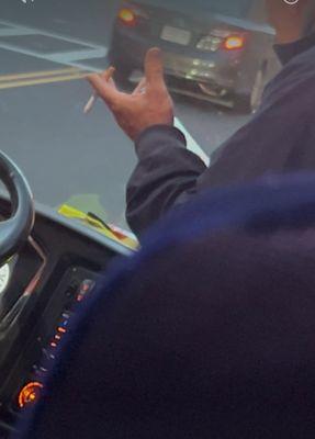 Driver with litt cigarette on bus