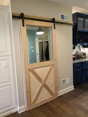 barn doors in installed between mudroom to kitchen