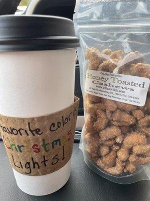 Latte with a random handwritten note on my sleeve and a bag of honey toasted cashews