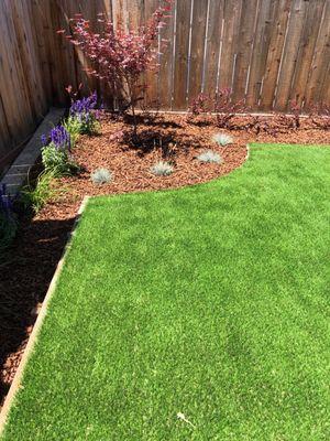 Wood chips, plants, and artificial turf installed.