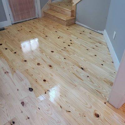 Putting the first coat of polyurethane on pine hardwood floors.