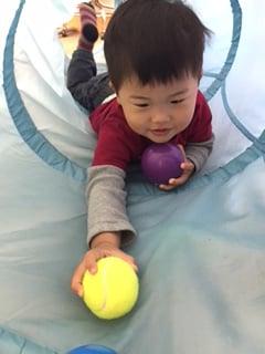 Learning to crawl and reach balls inside the tunnel.