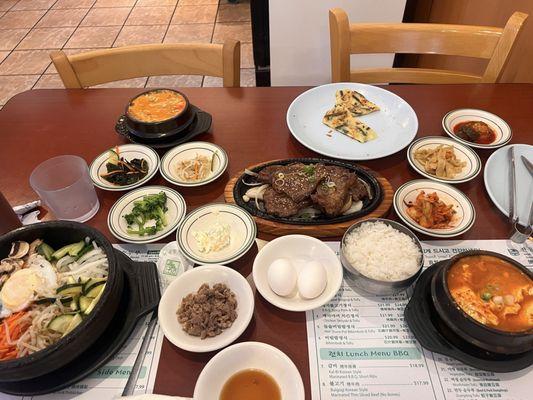 All side dishes and Bibimbap and Beef short rib and tofu soup