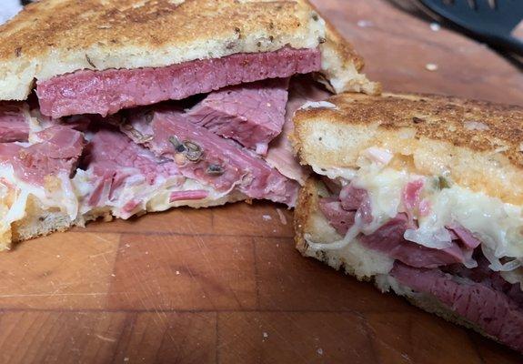 REUBEN (house-made corned beef, Swiss cheese, sauerkraut, 10,000 island dressing, on grilled rye bread)