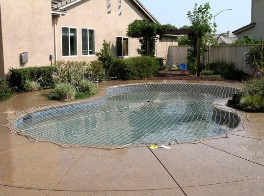 Katchakid Pool Safety Net -in desert sand. Provides an extra layer of safety.