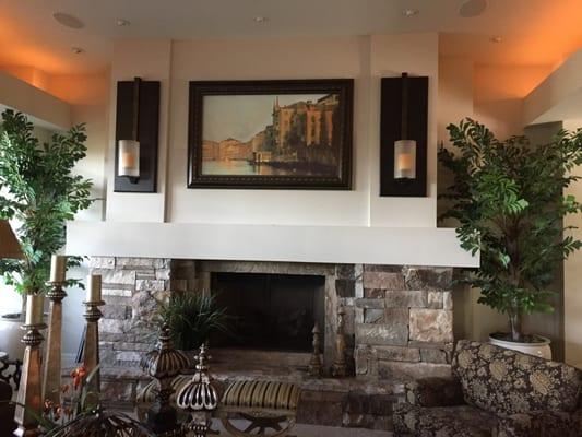 4k Flat Screen TV mounted above fireplace behind art 2